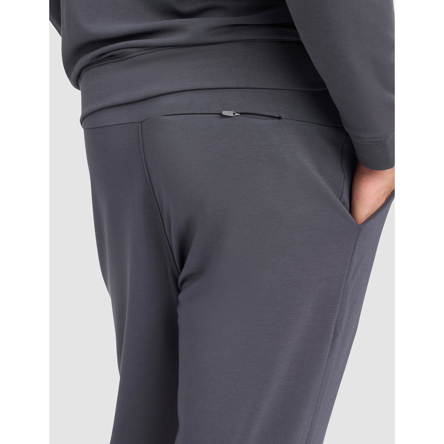 Gray sweatpants worn by a person on a light gray background