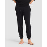 Person wearing black sweatpants on a light gray background