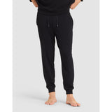 Person wearing black sweatpants on a light gray background