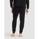 Person wearing black sweatpants on a light gray background