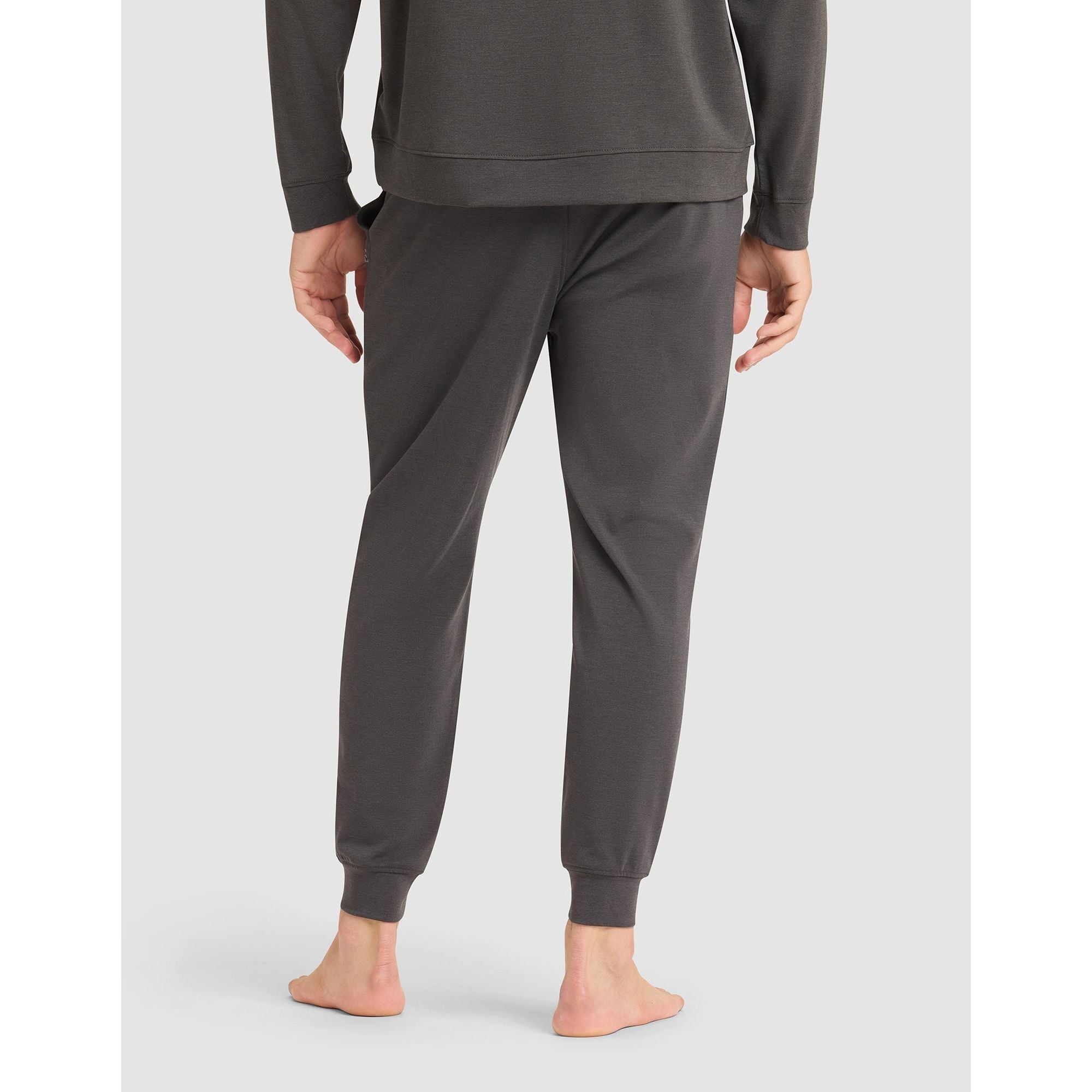 Person wearing gray sweatpants on a light gray background