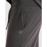 Dark gray sweatpants with a logo on a light gray background