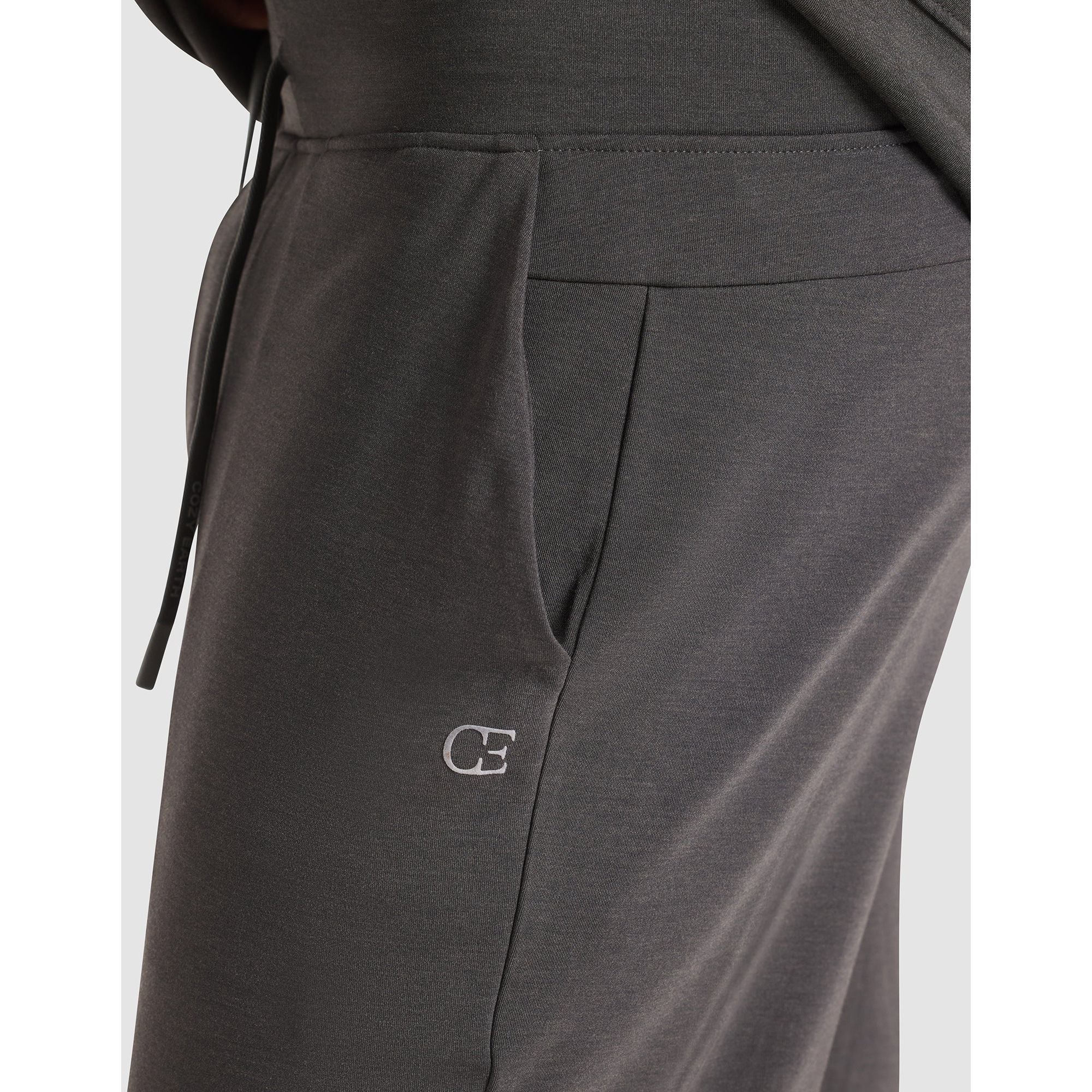 Dark gray sweatpants with a logo on a light gray background
