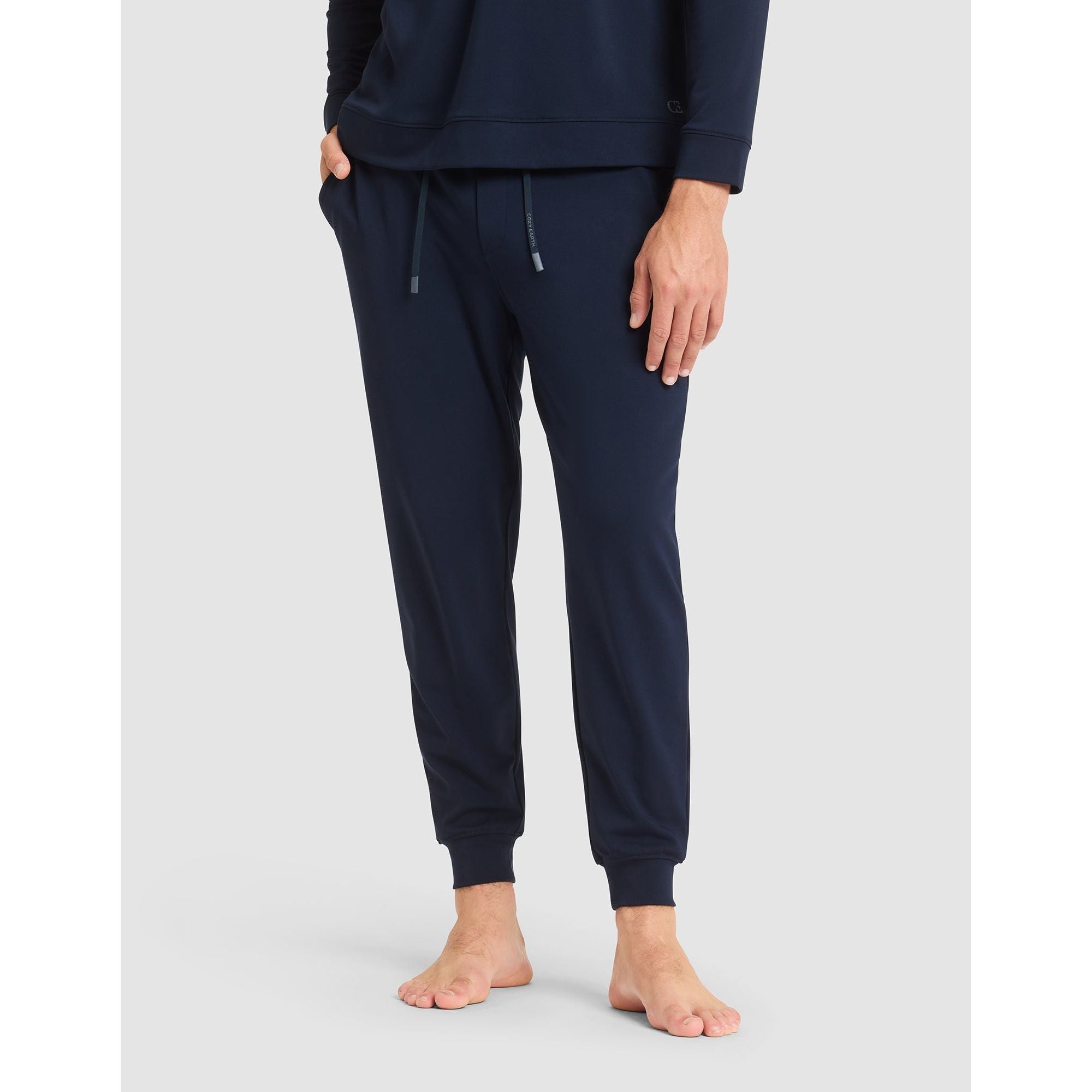 Navy blue sweatpants worn by a person on a light gray background