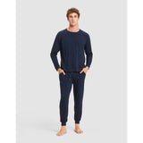 Man wearing navy blue pajama set on a light gray background