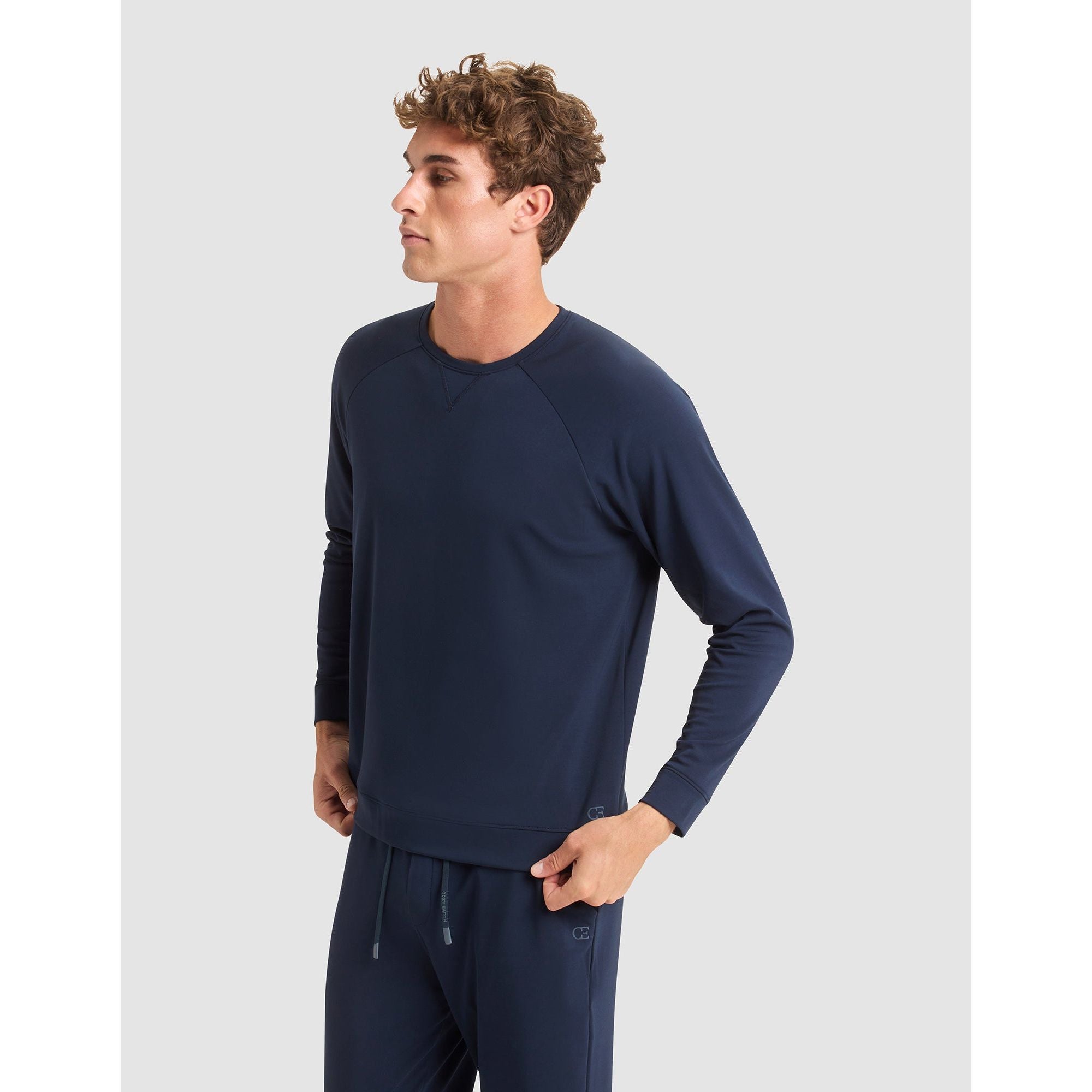 Man wearing a navy long-sleeve shirt and pants on a light gray background