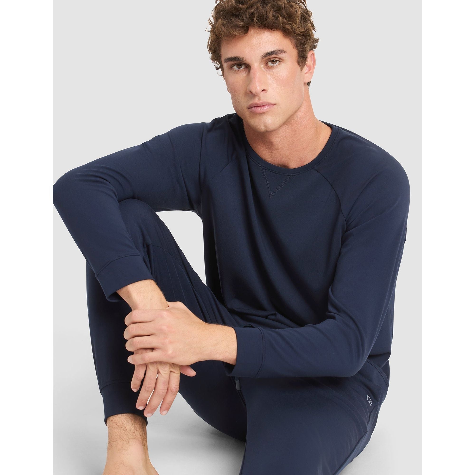 Man wearing a navy blue long-sleeve shirt and pants on a light gray background
