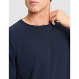 Navy blue long-sleeve shirt worn by a person on a light gray background