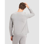 Person wearing a gray long-sleeve top and pants on a light gray background
