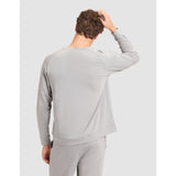 Person wearing a gray long-sleeve top and pants on a light gray background