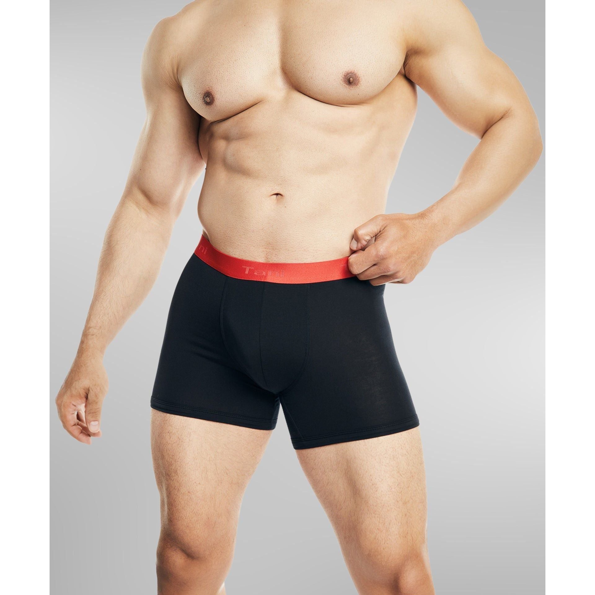 Front view of man wearing SilkCut black boxer briefs with red waistband showing ergonomic pouch and sleek fit