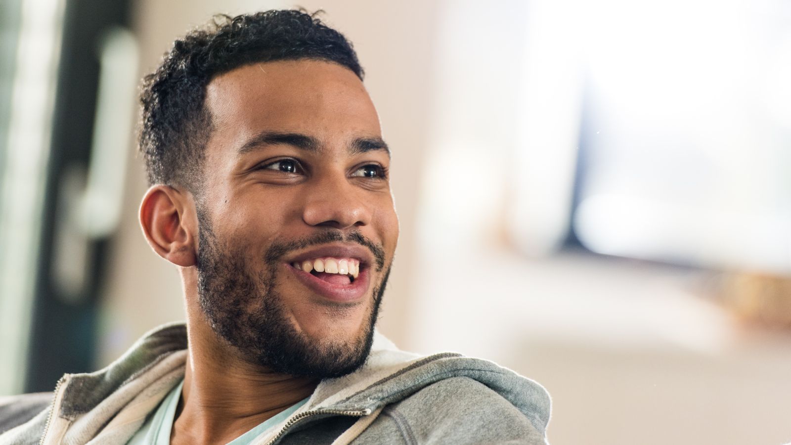 Man sitting comfortably in boxer briefs made for sensitive skin and smiling confidently