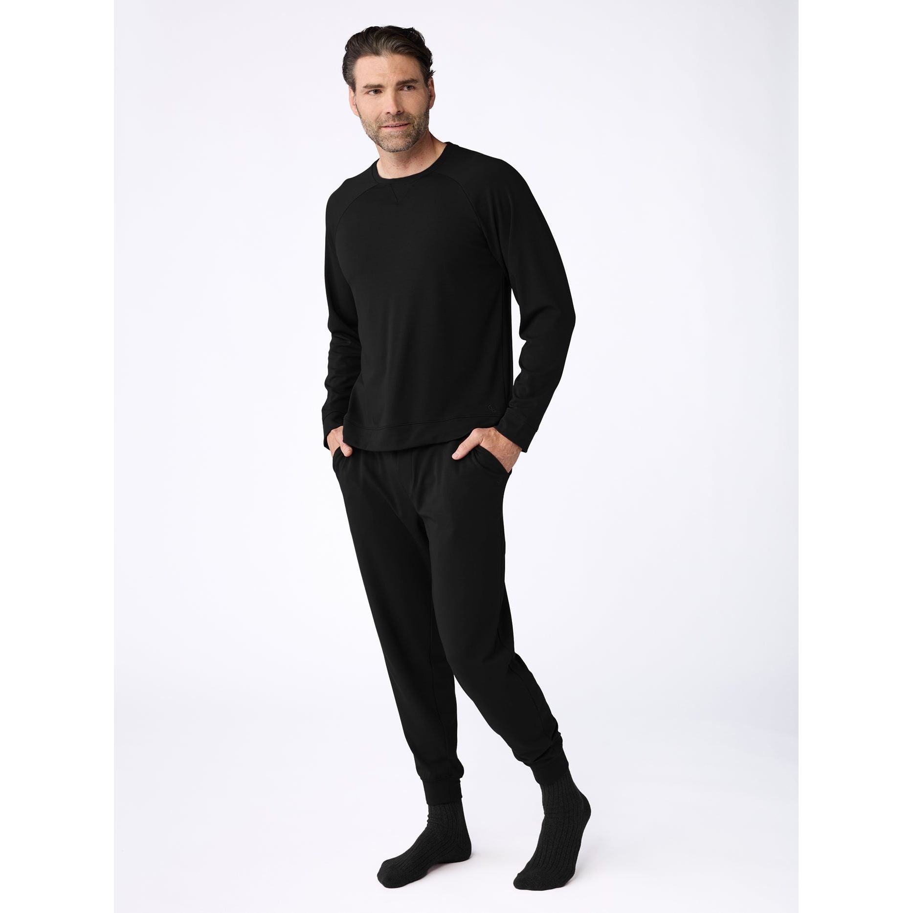 Man wearing a black outfit on a white background