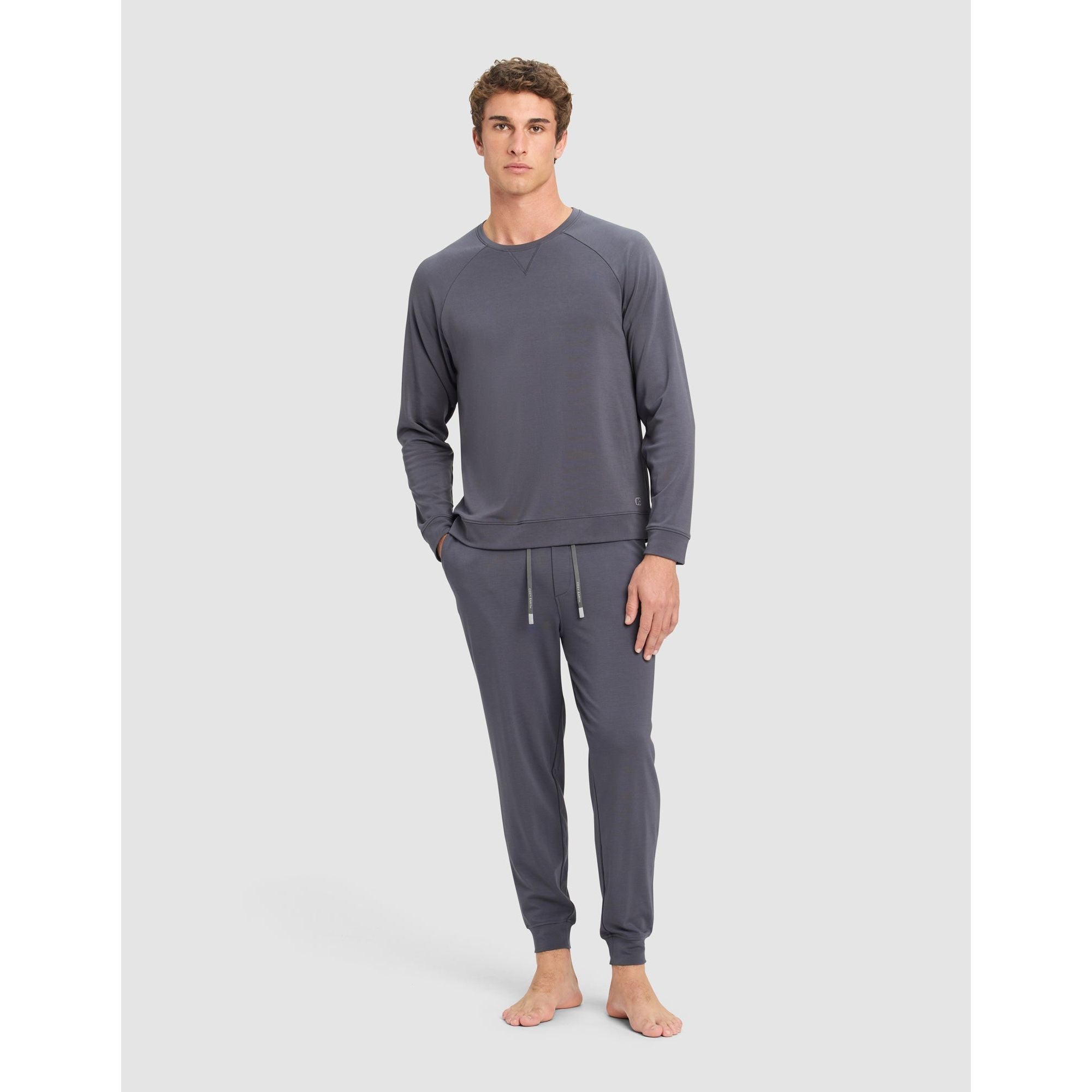 Man wearing a gray pajama set on a light gray background