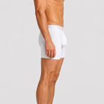 A side-profile view of a male model wearing SilkCut Underwear white boxer briefs against a light gray studio background.