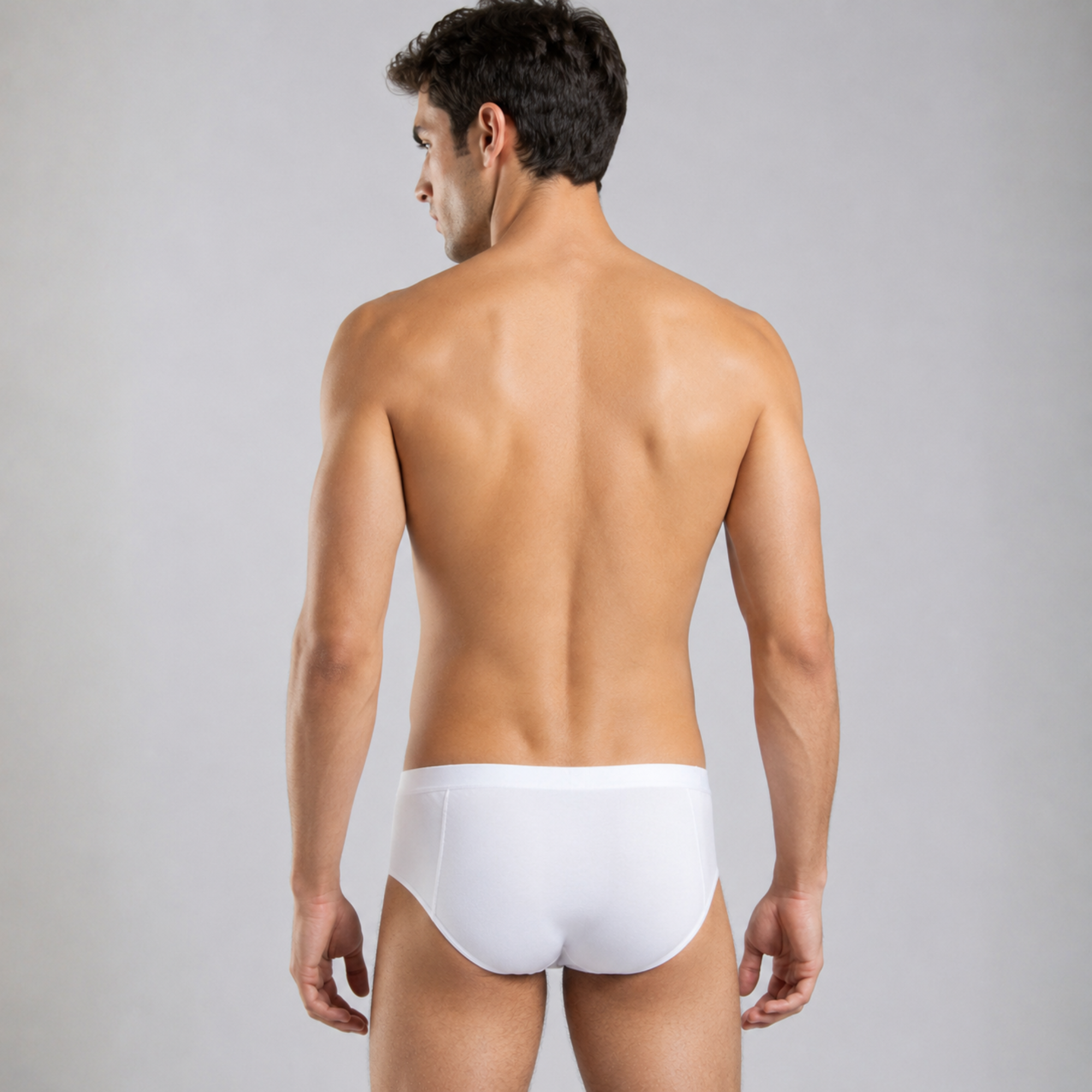 A man shown from the back wearing a pair of silkcut micro modal air white briefs against a plain light gray studio background.