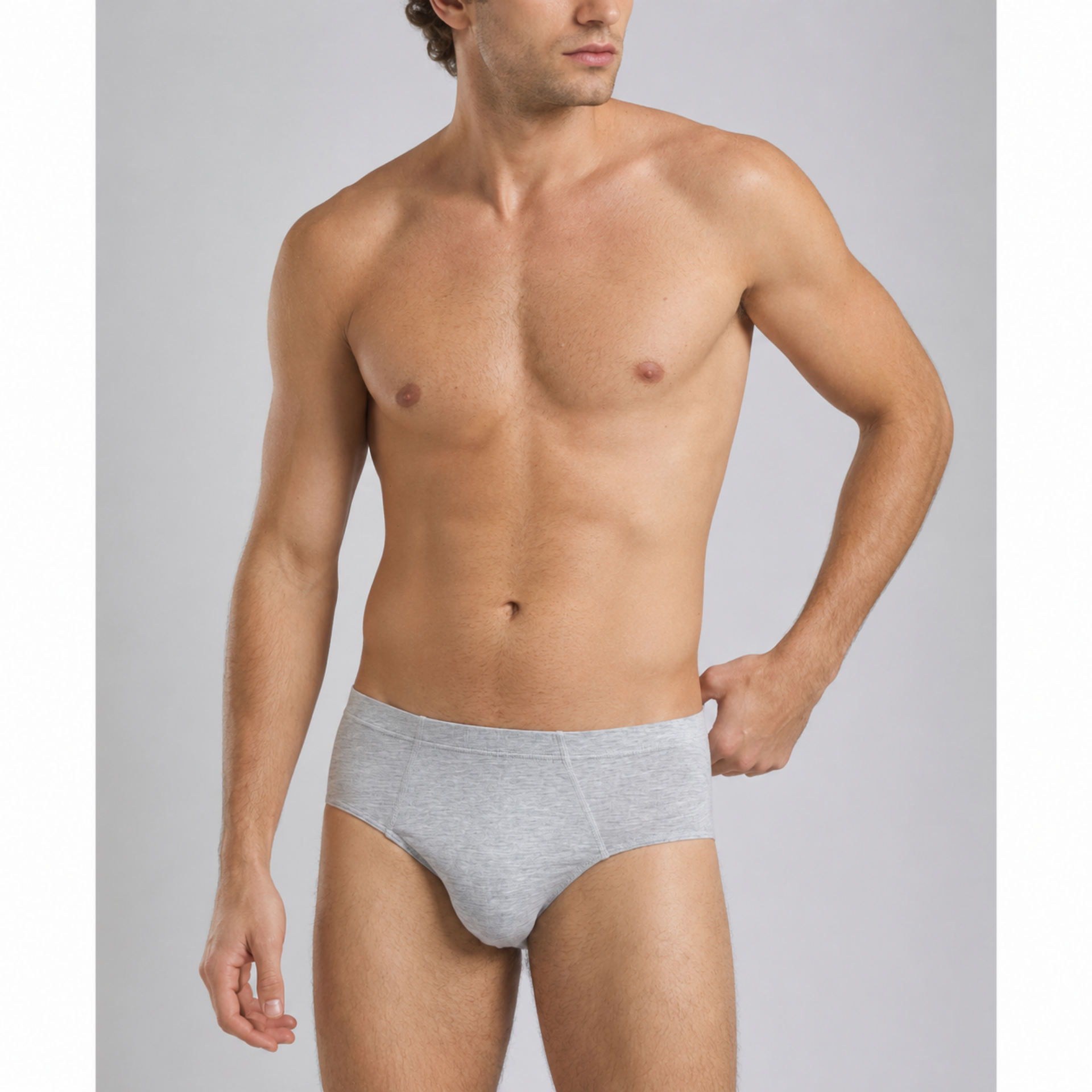 A shirtless male model wearing light gray heathered briefs, shown from the waist up against a plain light gray studio background. silkcut underwear