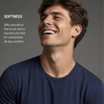 A smiling man wearing a silkcut underwear  micro modal air navy blue crew-neck t-shirt, shown from the chest up against a dark gray background, with text on the left describing the soft, silky feel of the fabric.
